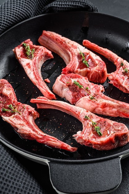Raw lamb chops and spices on a pan