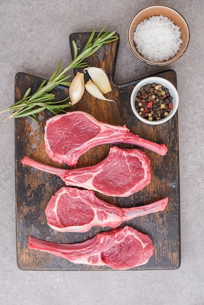 Raw lamb chops on stone background