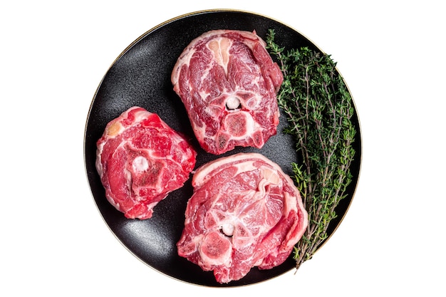 Raw Lamb Gerdan lamb neck chops on a plate with herbs Isolated on white background