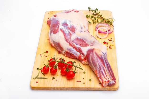 raw lamb leg, loin on bone with herbs, meat wooden cutting board, on a white isolated background