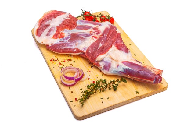 raw lamb leg, loin on bone with herbs, meat wooden cutting board, on a white isolated background