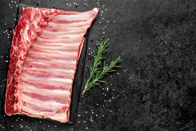 Raw lamb ribs with spices on a stone background  