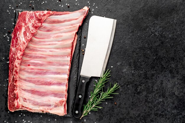 Raw lamb ribs with spices on a stone background  