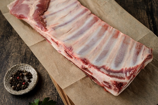 Raw lamb ribs on a wood on dark background