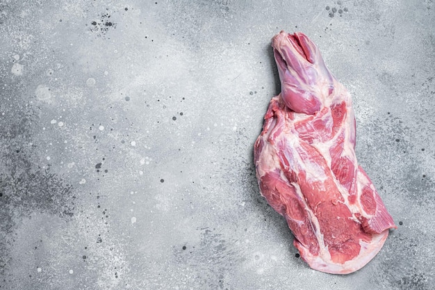 Raw lamb shoulder meat on butcher table Gray background Top view Copy space