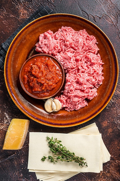 Raw lasagna ingredients and products for pasta. Dark background. Top view.