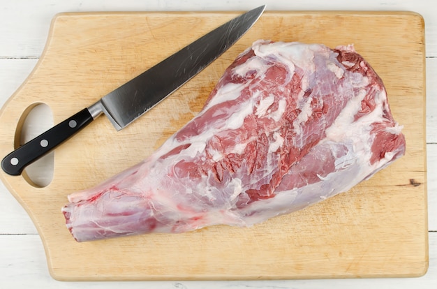 Raw leg of lamb on a cutting board