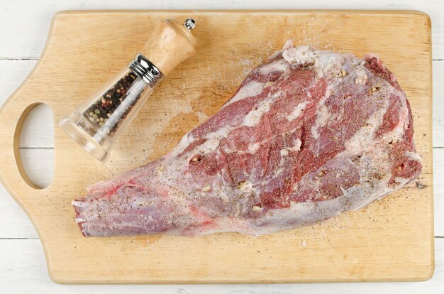 Raw leg of lamb on a cutting board