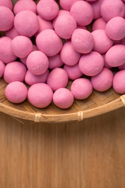 Raw little tangyuan in a sieve over wooden table