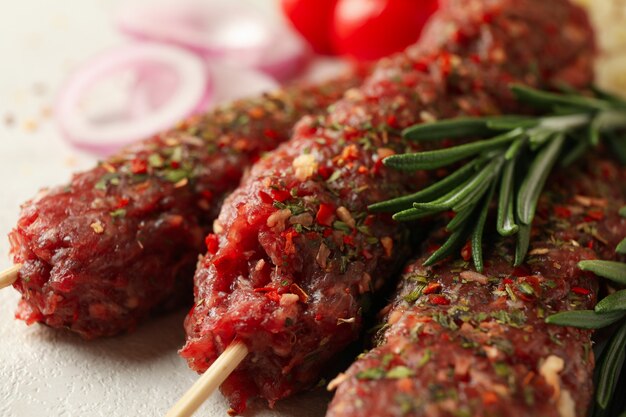 Raw lula kebab, herbs and spices, close up