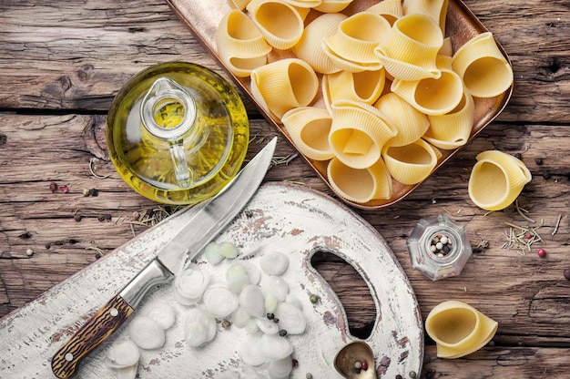 Raw macaroni on wooden background