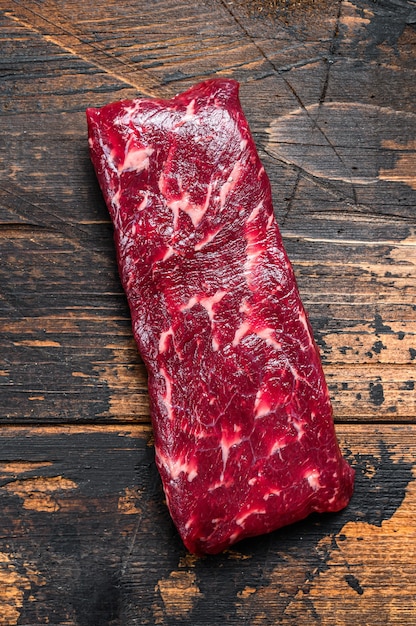 Raw machete or skirt beef steak. Dark wooden background. Top view.