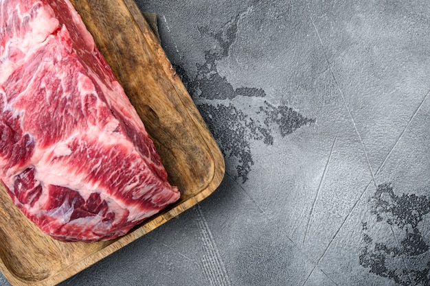 Raw Marble beef black Angus, ribeye or scotch fillet set, on gray stone background, top view flat lay, with copy space for text