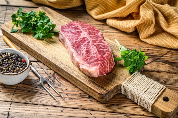 Raw marble beef meat steak. wooden table. Top view.