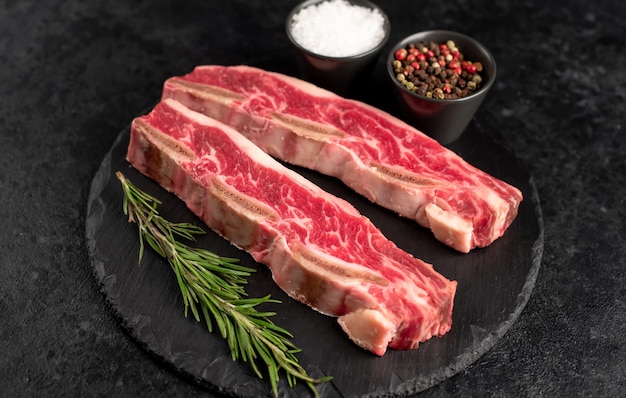 raw marbled beef ribs on stone background