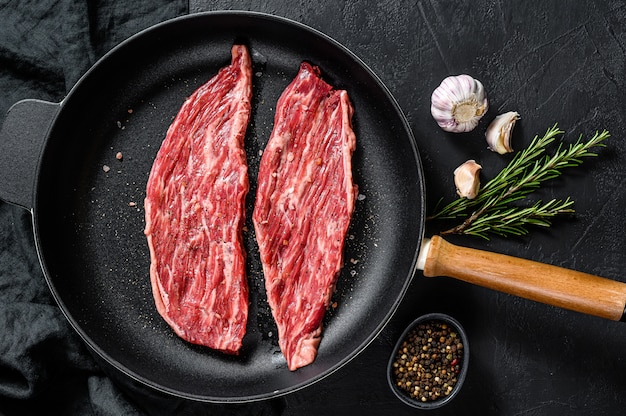 Raw marbled beef steak in a frying pan. 