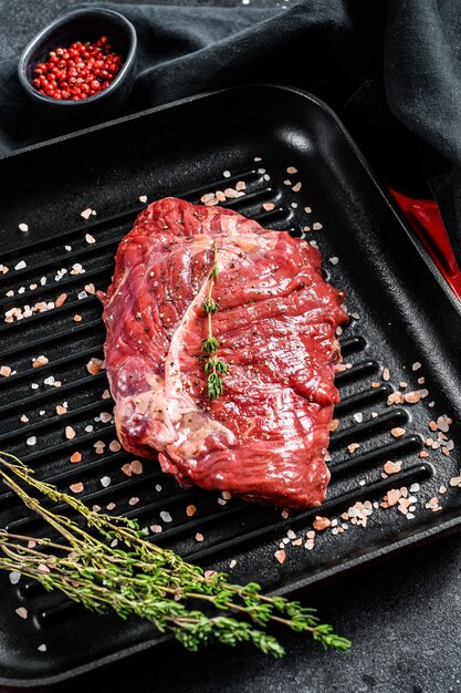 Raw marbled beef steak on a grill pan