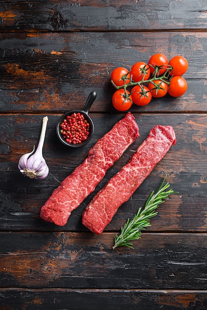 Raw marbled beef steak with pink pepper and rosemary