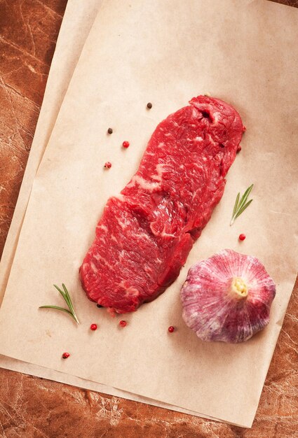 Raw marbled meat Steak and seasonings on dark marble background