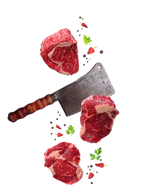 Raw marbled ribeye steak and butchers knife isolated