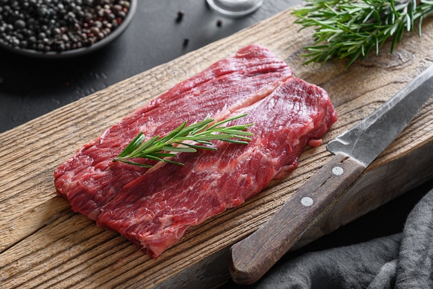 Raw marbled ribeye steak with rosemary sprig