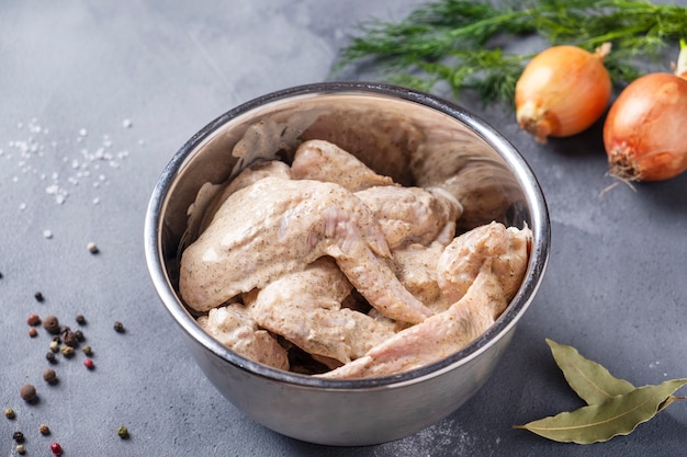 Raw marinated chicken wings in a bowl