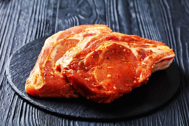 Raw marinated pork chops on a plate