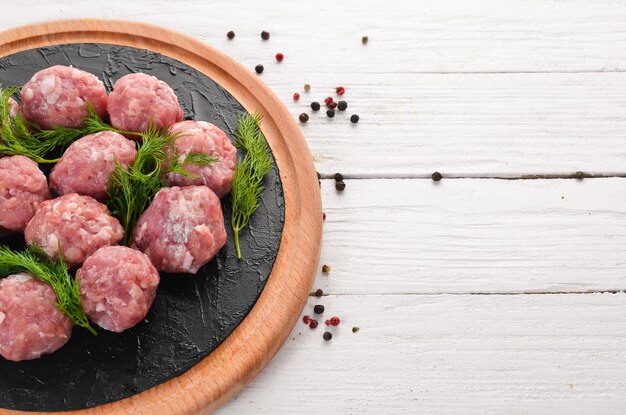 Photo raw meat balls on a white wooden background top view free copy space