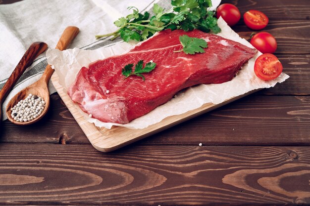 Raw meat beef fillet on brown wooden board close up