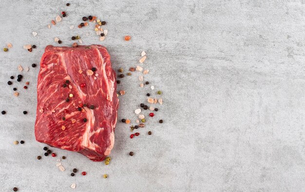 Raw meat beef fillet and pepper on a marble background copy space