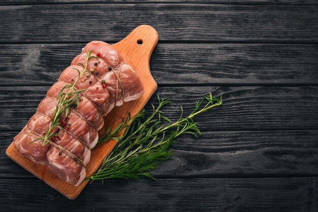 Raw meat Beef fillet with rosemary and spices on a black wooden background Top view Free space for text