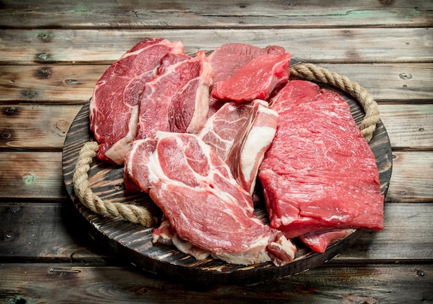 ボード上の生肉の牛肉と豚肉のステーキ
