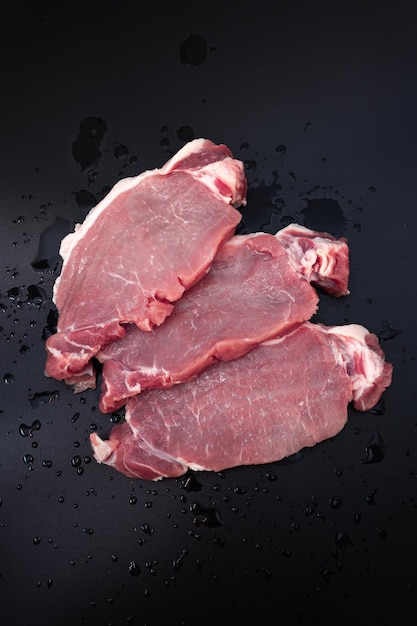 어두운 배경 평면도에 있는 생고기 쇠고기 스테이크
