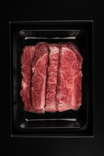 Raw meat in a box on a black background