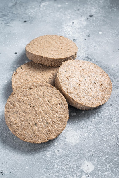 Raw Meat Free Plant Based Burger patties, vegetarian cutlets. Gray background. Top view.