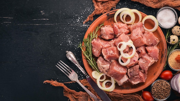 Raw meat is cooked for shish kebab on a wooden background On the plate Top view Free space for text