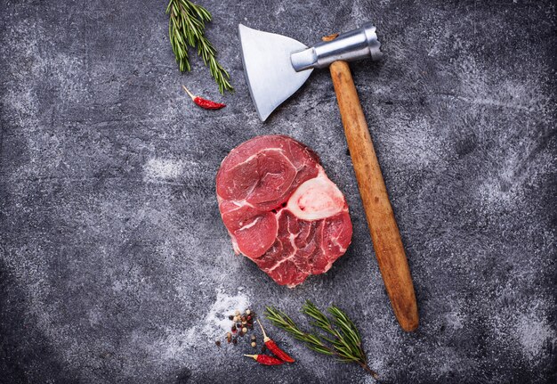 Photo raw meat osso buco and butchers axe