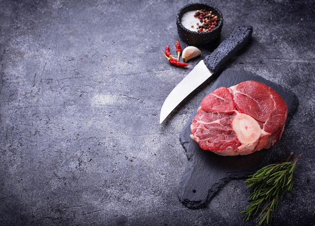 Raw meat osso buco on slate cutting board