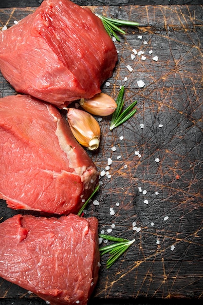 Raw meat Pieces of fresh beef with salt and rosemary