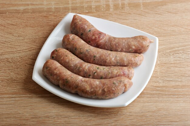 Raw meat sausages kupaty in white plate