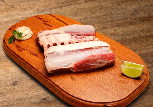 Raw meat selection on wooden cutting board.