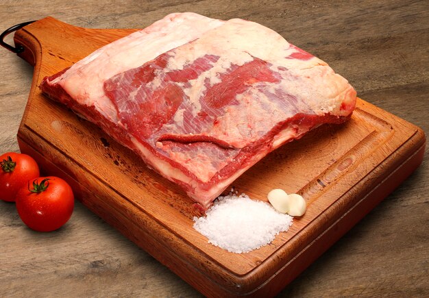 Raw meat selection on wooden cutting board.