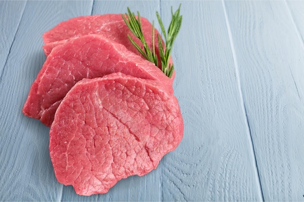 Raw Meat slices on wooden table