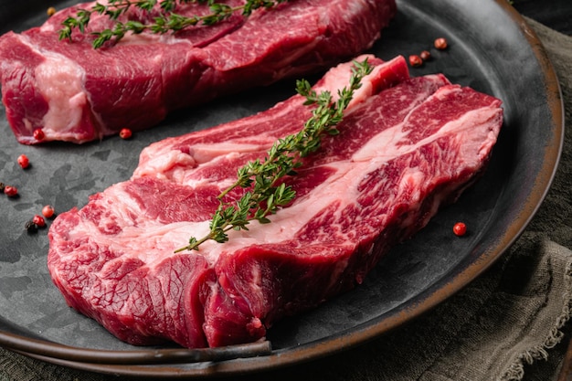 Raw meat steaks set, on old dark  wooden table background