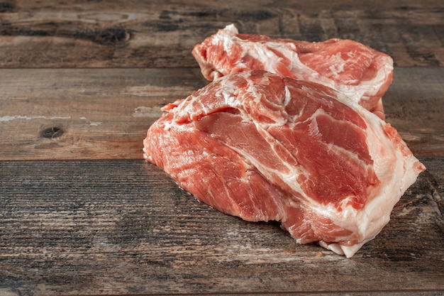 生肉。木製の素朴なテーブルに生の豚肉2枚