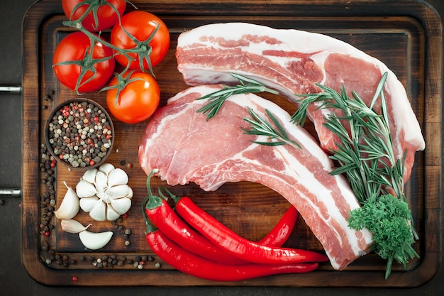 Carne cruda con spezie in una composizione con accessori da cucina