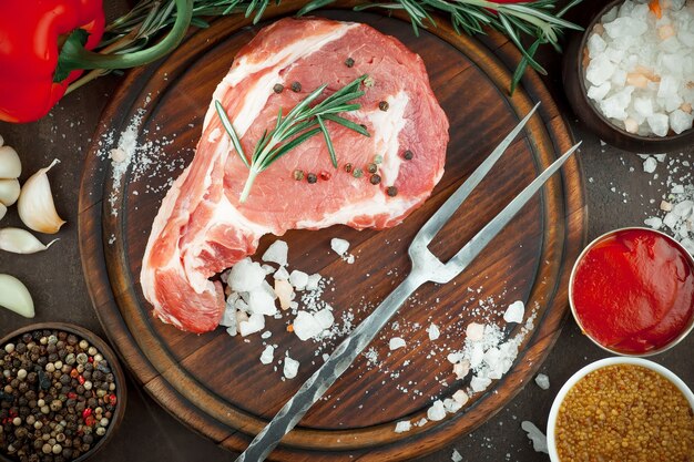 Raw meat with spices in a composition with kitchen accessories