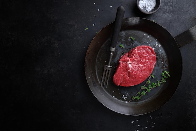 Raw meat with spices and herbs on table