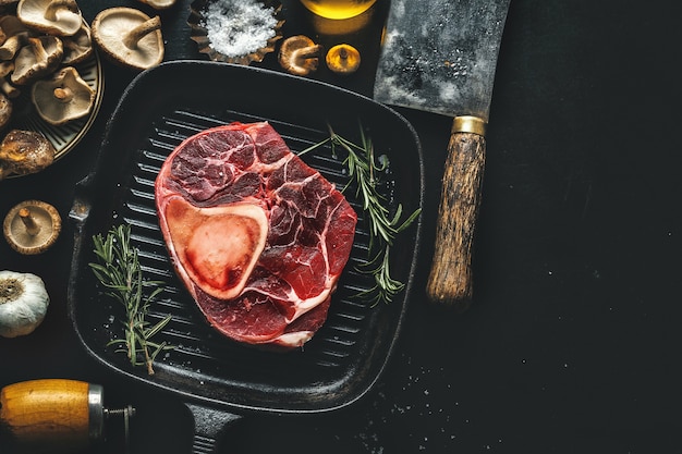 Raw meat with vegetables and spices on dark table. View from above.