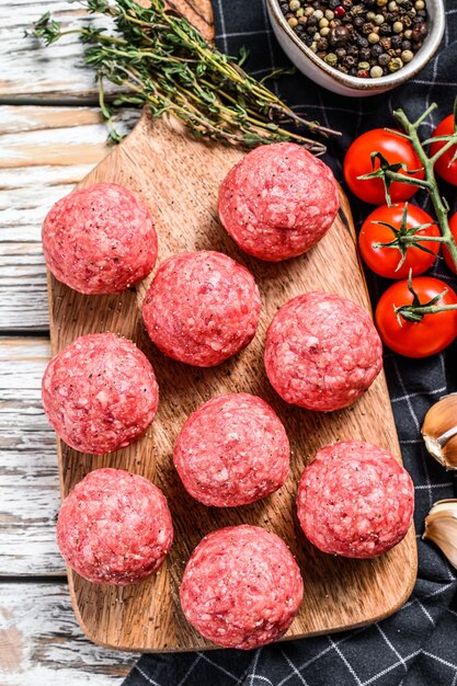 Raw meatballs made from ground beef. White background. Top view.